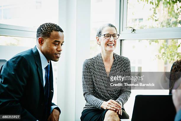smiling businesswoman listening during meeting - leanintogether stock pictures, royalty-free photos & images