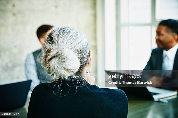 mature businesswoman listening during meeting - leanintogether stock pictures, royalty-free photos & images