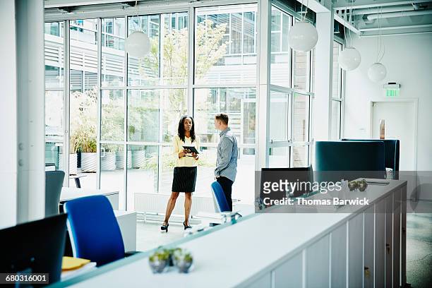 coworkers discussing project on digital tablet - leanintogether stock pictures, royalty-free photos & images