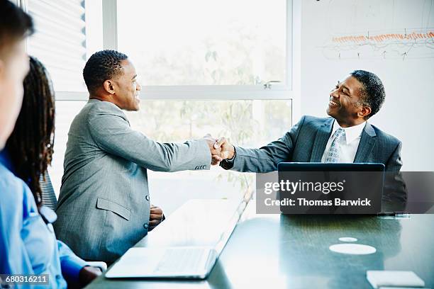 businessmen shaking hands during meeting in office - vestimenta de negocios formal fotografías e imágenes de stock