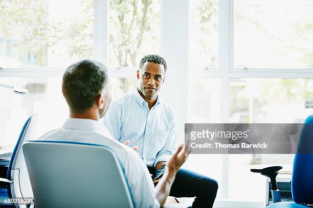 businessmen in discussion at office workstation - solutions expertise stockfoto's en -beelden