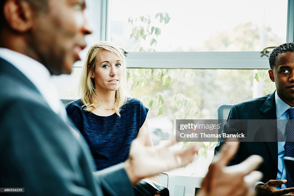 Businesswoman listening to coworker during meeting