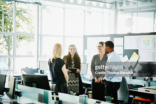 smiling businesswoman leading informal meeting - leanintogether stock pictures, royalty-free photos & images