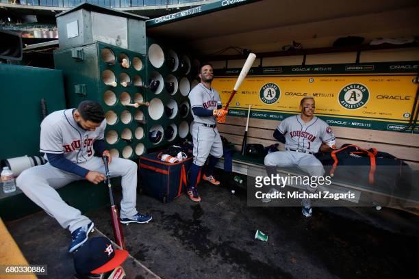 Marwin Gonzalez, Jose Altuve and Carlos Correa of the Houston Astros relax in the dugout prior to the game against the Oakland Athletics at the...