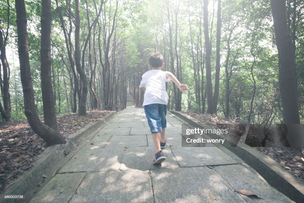 Young boy running in forest