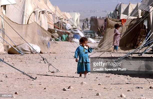 Young Afghan girl eats a piece of bread at the Chaman refugee camp November 8, 2001 on the Pakistan border with Afghanistan. The UNHCR has estimated...