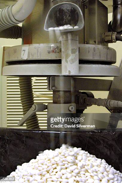 Antibiotics drop out of a pill-compressor at the Dexxon pharmacuticals plant on November 8, 2001 in the Israeli town of Or Akiva. Dexxon produces...