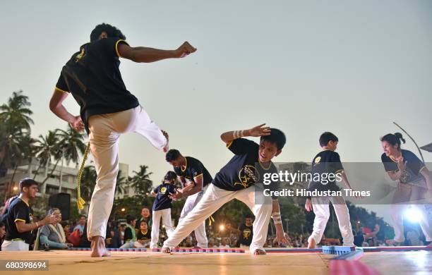 People perform Capoeira during Batizado event at Carter Road, on May 7, 2017 in Mumbai, India. Capoeira is a Brazilian martial art that combines...