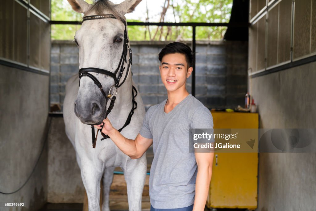 一位年輕男性騎馬者肖像站著他的馬