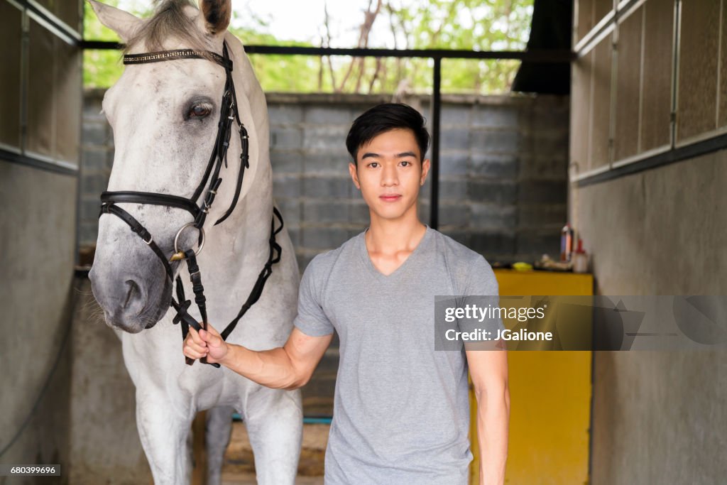 一位年輕男性騎馬者肖像站著他的馬