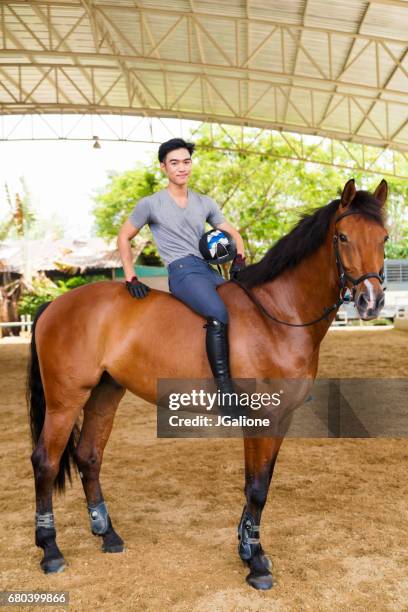 ritratto di un giovane maschio seduto sul suo cavallo - horse and male and riding foto e immagini stock