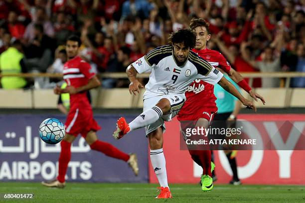 Al-Wahda Jorge Valdivia kicks the ball as Persepolis' Farshad Ahmadzadeh runs to defend during the Asian Champions League football match between...