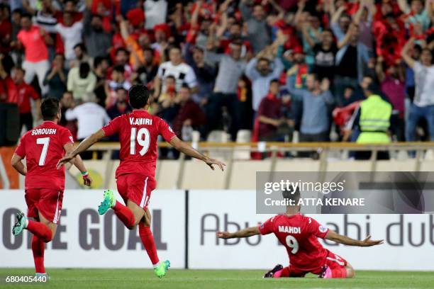 Persepolis' Mehdi Taremi celebrates with the fans after scoring a goal during the Asian Champions League football match between UAE's Al-Wahda and...