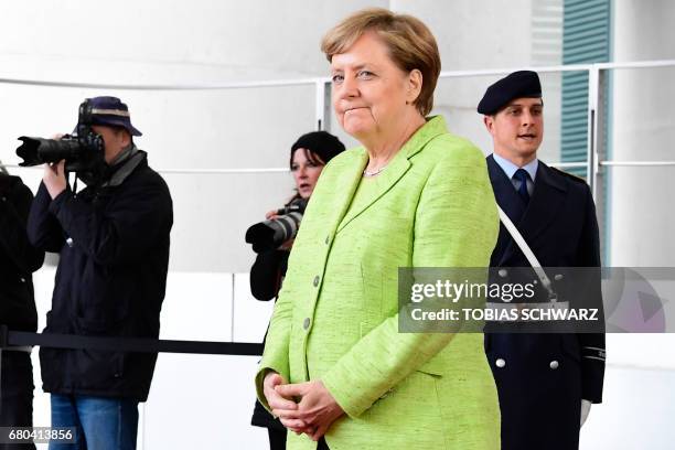 German Chancellor Angela Merkel waits to greet outgoing French President Francois Hollande at the Chancellery in Berlin on May 8 the day after the...