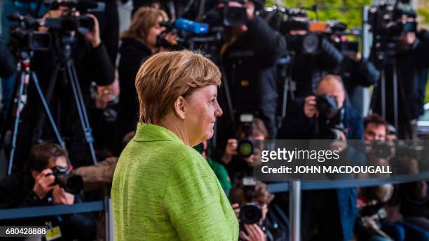 German Chancellor Angela Merkel prepares to greet outgoing French President Francois Hollande at the Chancellery in Berlin on May 8 the day after the...