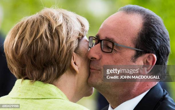 German Chancellor Angela Merkel greets outgoing French President Francois Hollande at the Chancellery in Berlin on May 8 the day after the French...