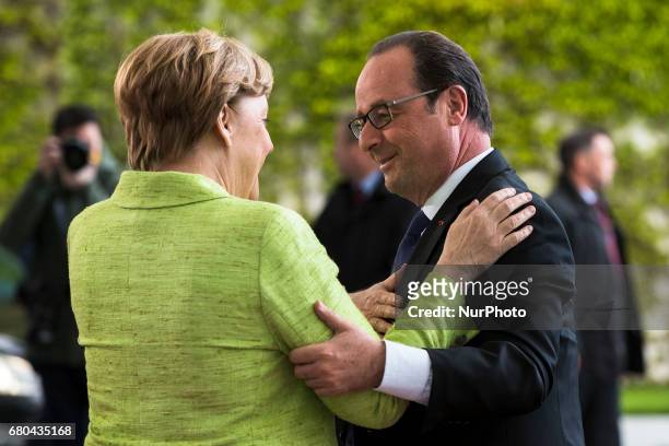 German Chancellor Angela Merkel greets outgoing French President Francois Holland upon his arrival at the Chancellery in Berlin, Germany on May 8,...