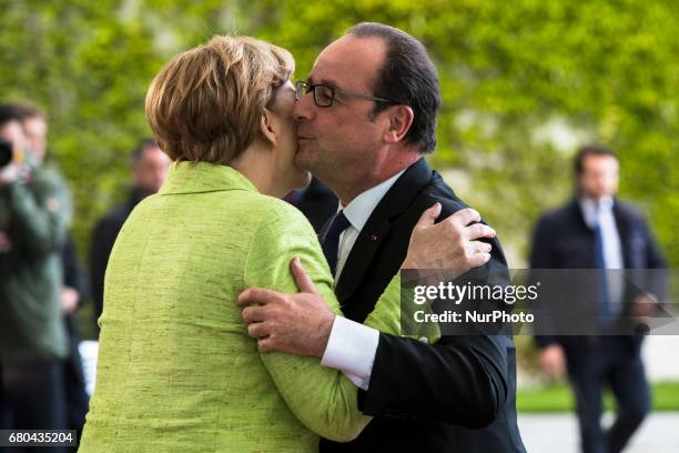 German Chancellor Angela Merkel greets outgoing French President Francois Holland upon his arrival at the Chancellery in Berlin, Germany on May 8,...