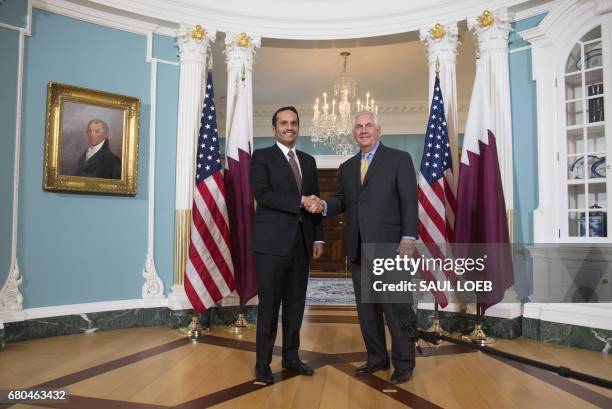 Secretary of State Rex Tillerson and Qatari Foreign Minister Mohammed bin Abdulrahman al-Thani shake hands prior to a meeting at the State Department...