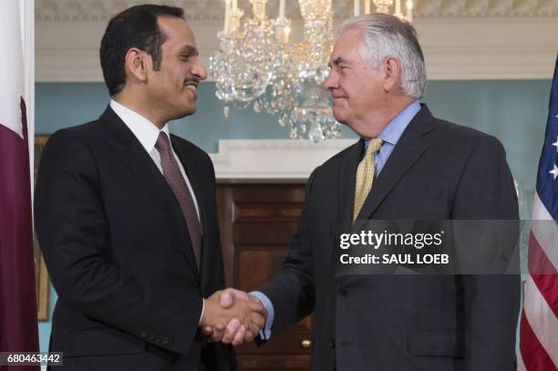 Secretary of State Rex Tillerson and Qatari Foreign Minister Mohammed bin Abdulrahman al-Thani shake hands prior to a meeting at the State Department...