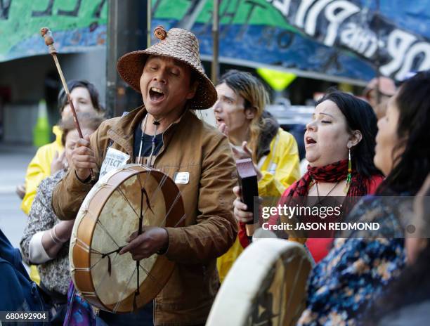 Paul Cheoketen Wagner and Chelalakem Bond sing as indigenous leaders and climate activists disrupt business at a Chase Bank branch to protest funding...