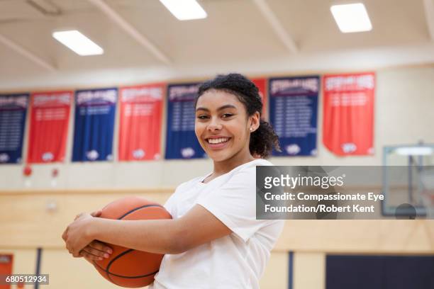 portrait of teenage basketball player in gym - teenage girl basketball photos et images de collection