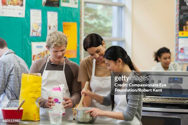 teacher helping teenage students in cookery class - 料理教室 ストックフォトと画像