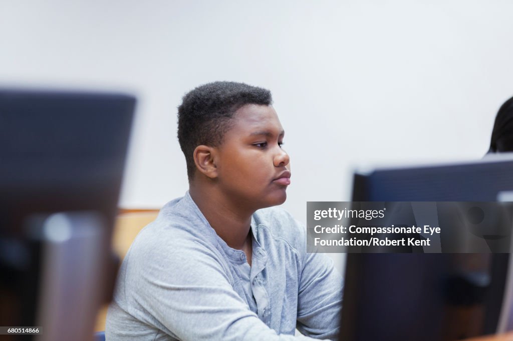 Teenage student working on computer in IT class