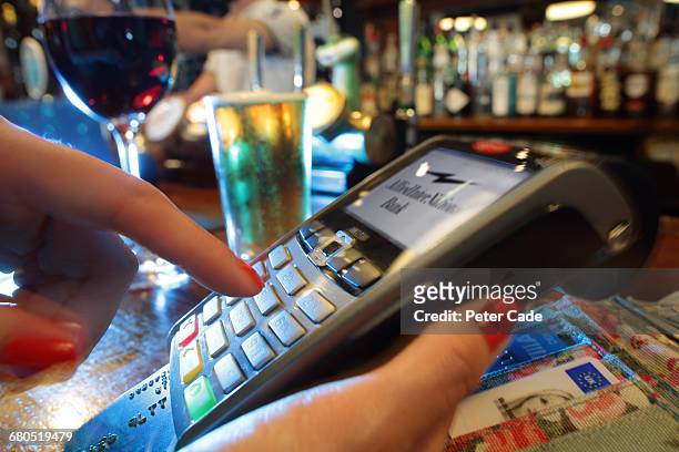 woman paying by card for drinks in pub - consumerism stock pictures, royalty-free photos & images