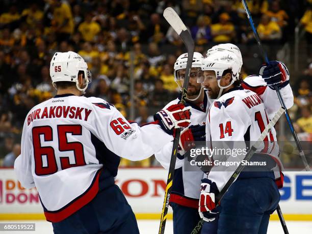 John Carlson of the Washington Capitals celebrates his goal against the Pittsburgh Penguins with Justin Williams and Andre Burakovsky in Game Six of...