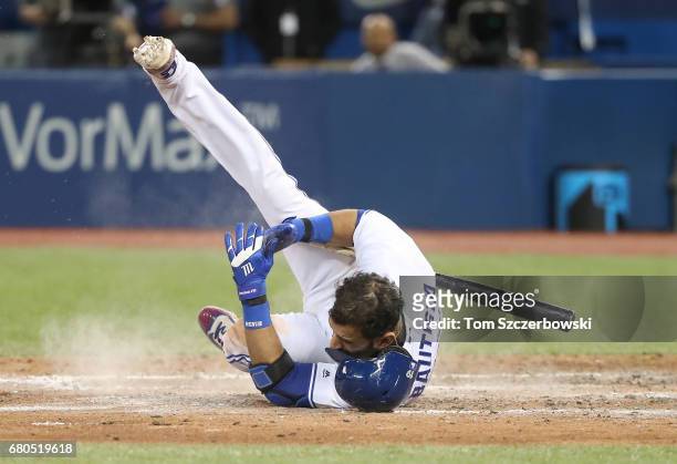 Jose Bautista of the Toronto Blue Jays falls after being knocked down by a high and inside fastball thrown by Zach McAllister of the Cleveland...