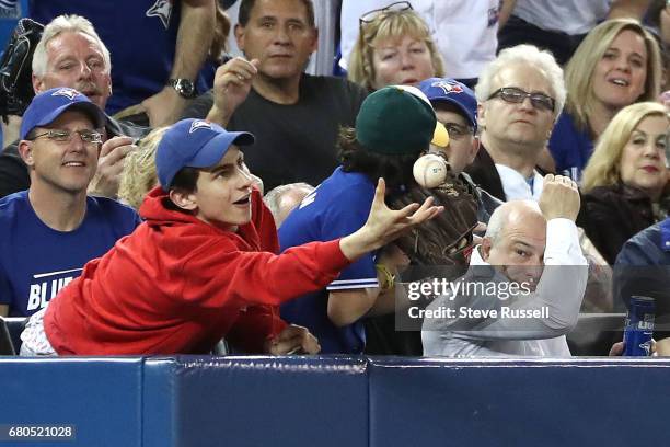 Fan catches a ball as the Toronto Blue Jays beat the Cleveland Indians 4-2 at Rogers Centre in Toronto. May 8, 2017.
