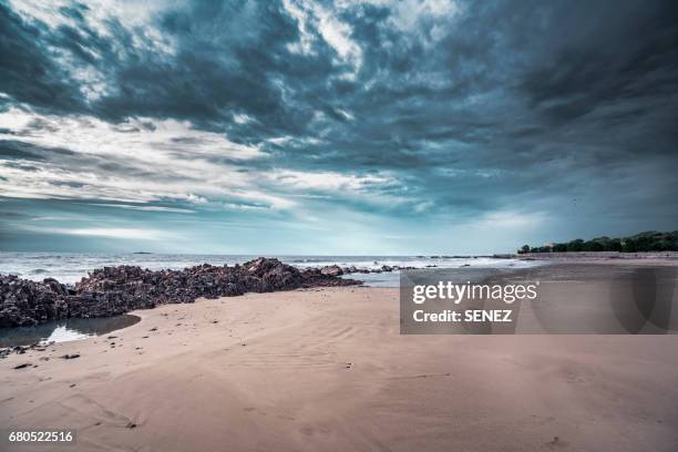 scenic view of sea against cloudy sky - dusk dark stock-fotos und bilder