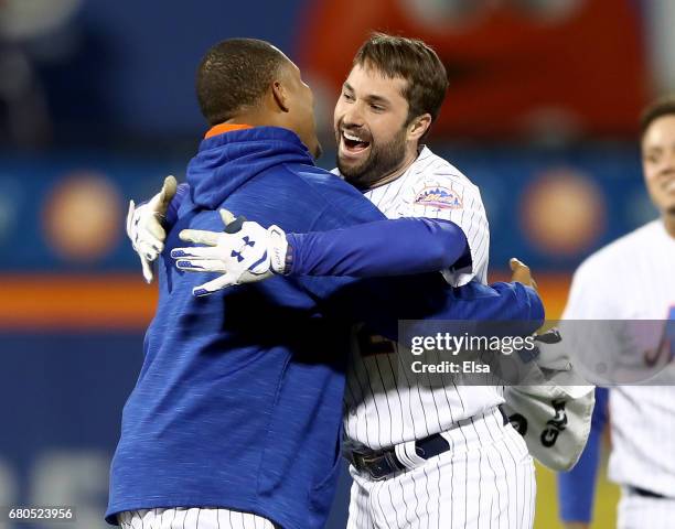 Jeurys Familia of the New York Mets congratulates Neil Walker after Walker drove in the game winning run against the San Francisco Giants on May 8,...