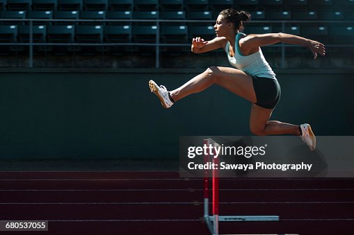 A runner taking on the hurdles. A runner taking on the hurdles.