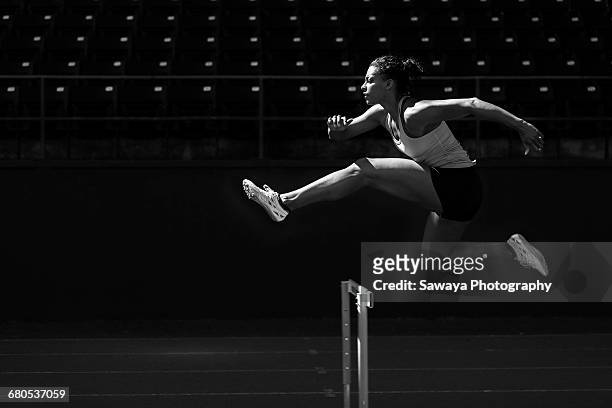 a runner taking on the hurdles. - chiaroscuro - fotografias e filmes do acervo