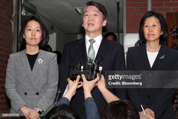 Ahn Cheol-soo, presidential candidate of the People's Party, center, speaks to members of media as his wife Kim Mi-kyung, right, and daughter Ahn...