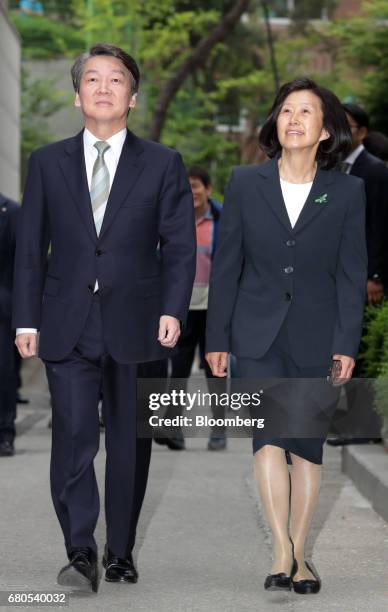 Ahn Cheol-soo, presidential candidate of the People's Party, left, and his wife Kim Mi-kyung arrive at a polling station in Seoul, South Korea, on...