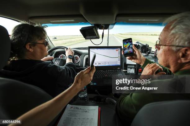 Traveling in a tornado scouting vehicle, support scientists Rachel Humphrey and Tim Marshall, a 40 year veteran of storm chasing, discuss the radar...