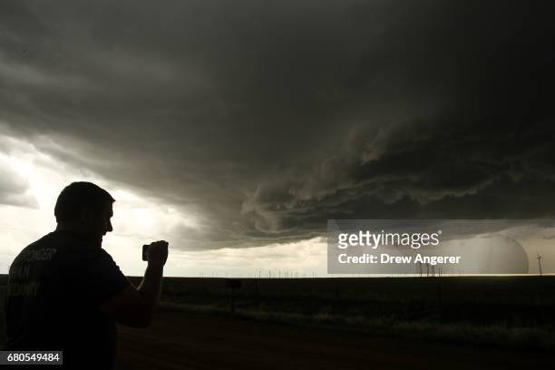 Storm chaser monitors a supercell thunderstorm as he streams live video on his smartphone, May 8, 2017 in Elbert County near Limon, Colorado. With...