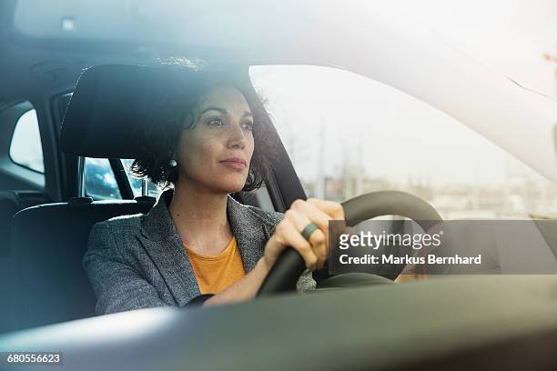 business woman driving her car - coat drive stock pictures, royalty-free photos & images