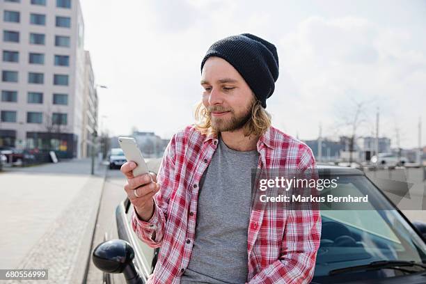 hipster texting on his phone - hipster candid stock pictures, royalty-free photos & images