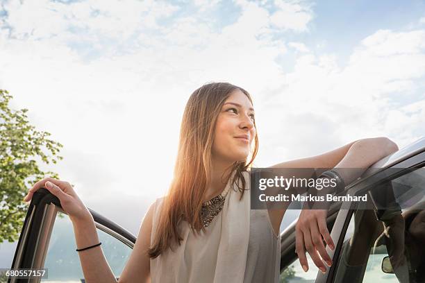 confident woman leaning at her new car - car ownership fotografías e imágenes de stock