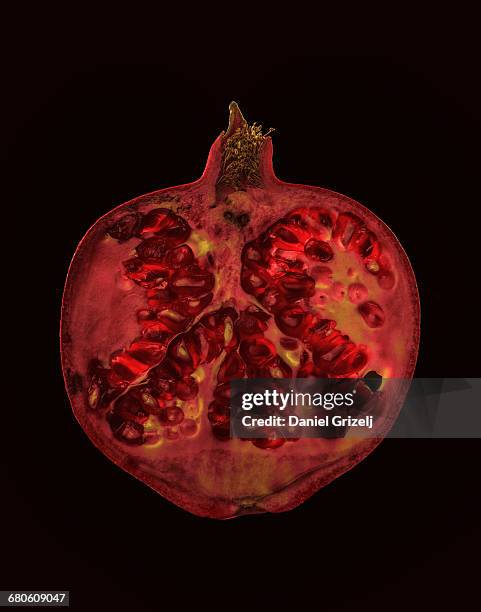 a pomegranate cut into a thin slice - enhanced features stock pictures, royalty-free photos & images