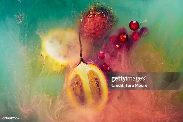 exotic fruit and paint shot underwater - exoticism stock-fotos und bilder