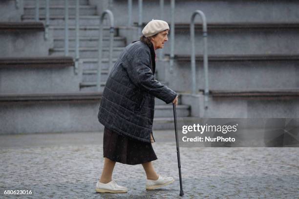 An elderly woman is seen walking in the rain on the Mill Island in Bydgoszcz, Poland on 6 May, 2017.