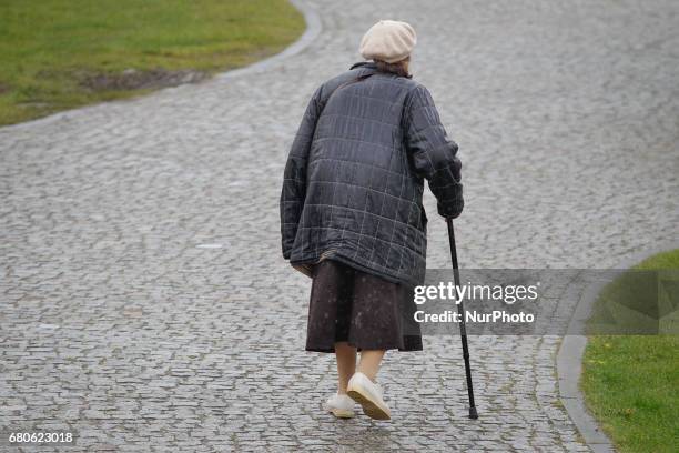 An elderly woman is seen walking in the rain on the Mill Island in Bydgoszcz, Poland on 6 May, 2017.