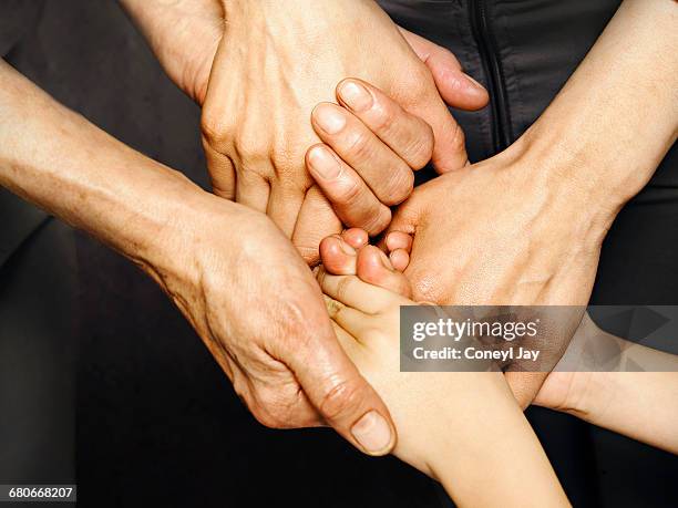 three generatios of women holding hands - holding hands stock pictures, royalty-free photos & images