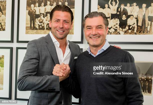 Goalkeeper Roman Weidenfeller of Borussia Dortmund poses next to BVB sport director Michael Zorc after he extended his contract with the club until...