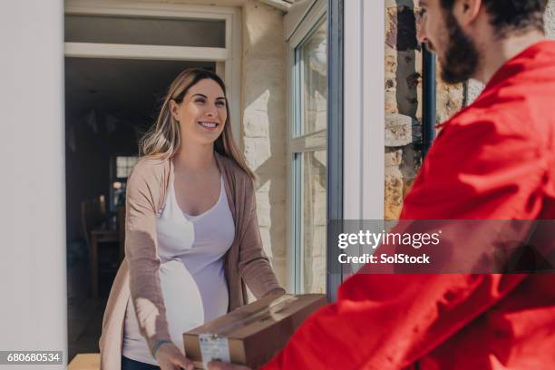 zwangere vrouw ontvangen van een levering - postbode stockfoto's en -beelden